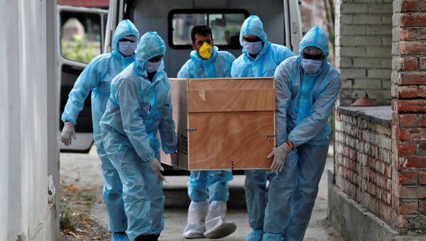 Los trabajadores médicos portan el cuerpo de un muerto por coronavirus en la India - Sputnik Mundo