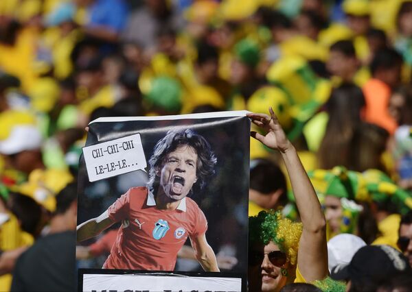 Hincha brasileño sostiene un cartel de Mick Jagger con la camiseta de Chile, octavos de final Copa del Mundo 2018 - Sputnik Mundo