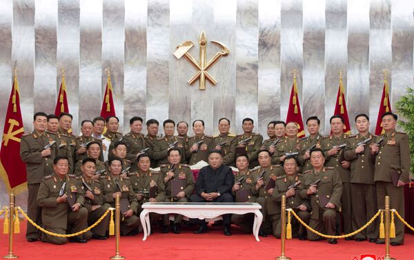 El líder norcoreano Kim Jong-un junto a generales y oficiales posan con las pistolas 'Paektusan' - Sputnik Mundo