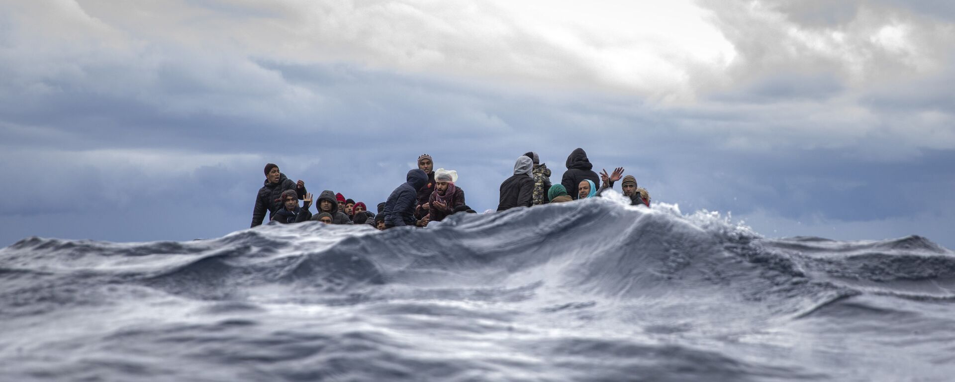 Inmigrantes en medio del mar Mediterráneo a punto de ser rescatados por la ONG española Open Arms. Enero 2020 - Sputnik Mundo, 1920, 18.09.2020