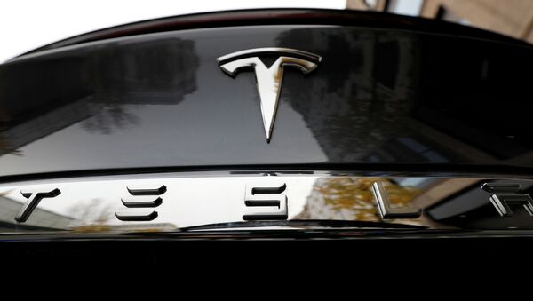 El logo de Tesla en un automóvil de la marca - Sputnik Mundo