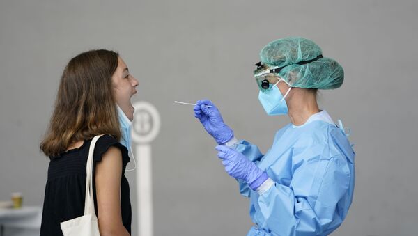 Una mujer realizándose una prueba PCR - Sputnik Mundo