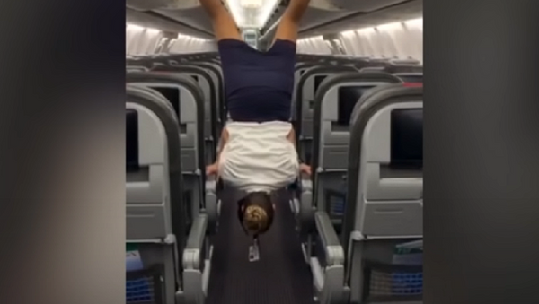 Una azafata realiza un atrevido truco a bordo de un avión - Sputnik Mundo