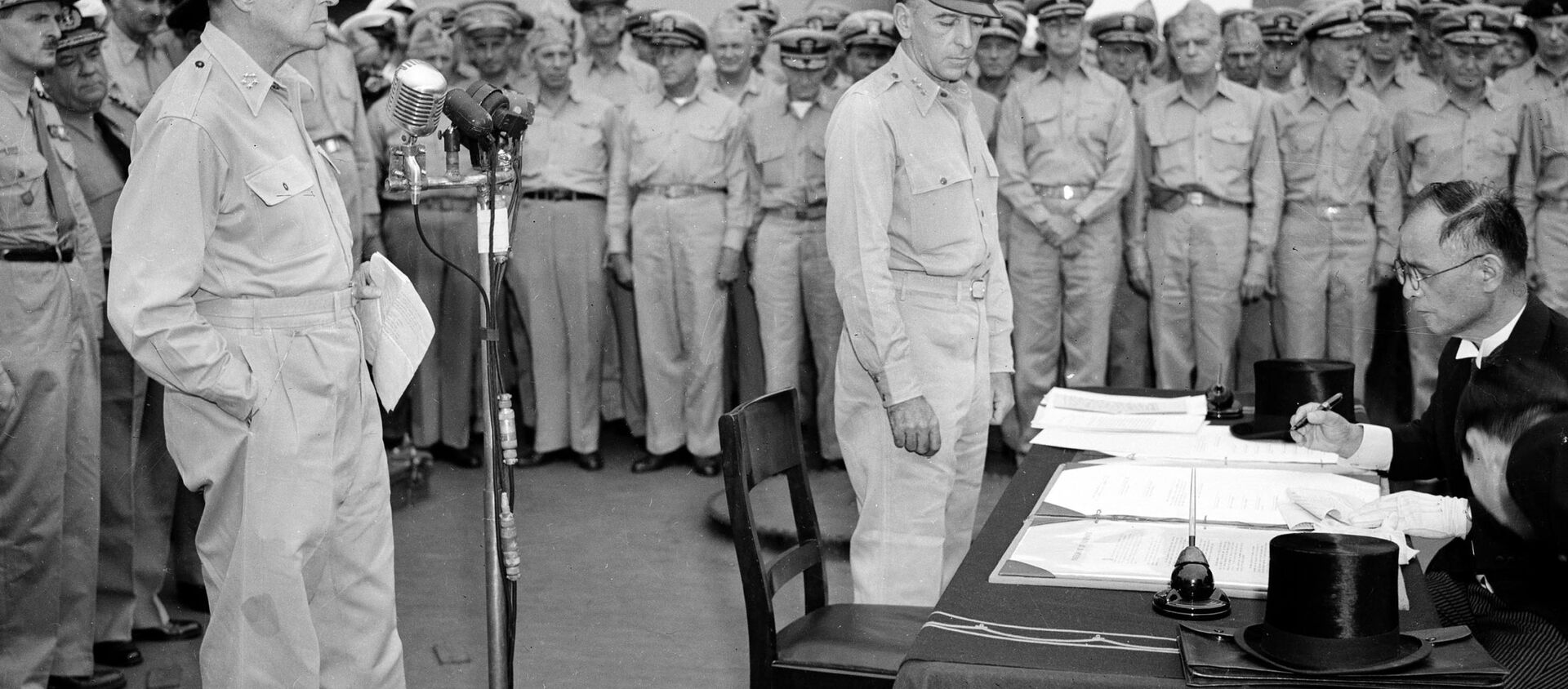 El general estadounidense Douglas MacArthur (izquierda) observa cómo el canciller japonés, Manoru Shigemitsu, firma el acta de rendición - Sputnik Mundo, 1920, 01.09.2020