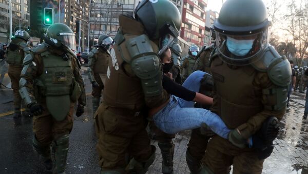 Carabineros deteniendo a una manifestante en Santiago, Chile - Sputnik Mundo