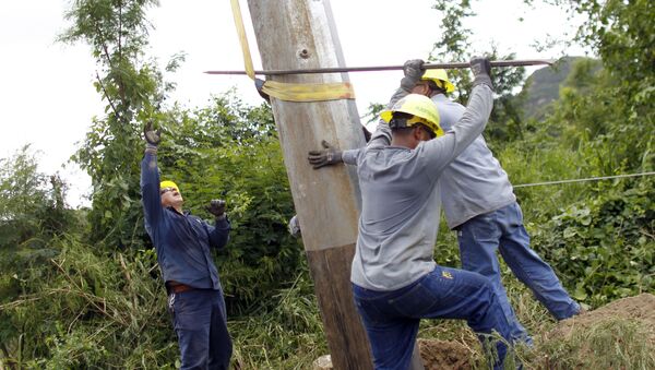 Trabajadores puertorriqueños arreglando un poste eléctrico en Ponce - Sputnik Mundo