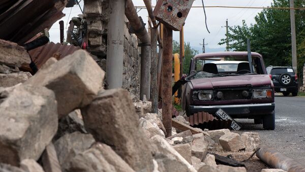 Дом и автомобиль, поврежденные в результате обстрелов общины Иванян Нагорного Карабаха - Sputnik Mundo