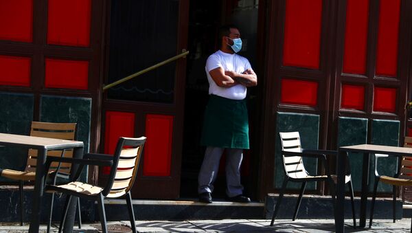 Un camarero con mascarilla esperando clientes en una terraza de Madrid - Sputnik Mundo