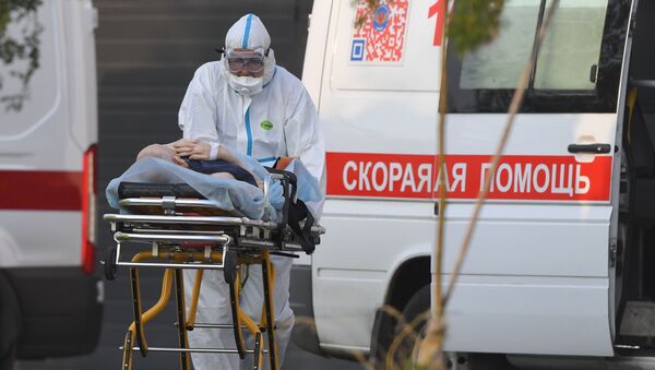 Un médico ruso transporta a un paciente con coronavirus - Sputnik Mundo