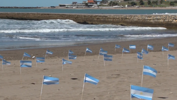Una ciudad argentina recuerda a los fallecidos por el COVID-19 con 504 banderas en la arena - Sputnik Mundo