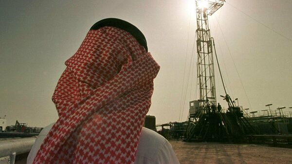 Un empleado de la compañía petrolera saudí Aramco observa el progreso de una plataforma situada en un yacimiento petrolero  - Sputnik Mundo