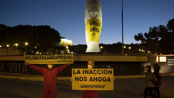 Activistas de Greenpeace colocan una mascarilla a una escultura gigante en la Plaza Colón  - Sputnik Mundo