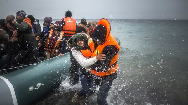 Refugiados y migrantes desembarcan en una playa (imagen referencial) - Sputnik Mundo