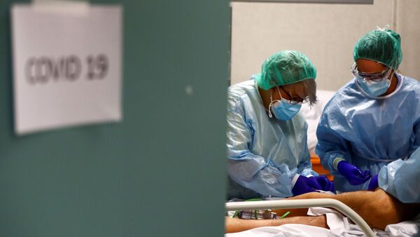 Trabajadores médicos atienden a un paciente infectado por  en España - Sputnik Mundo