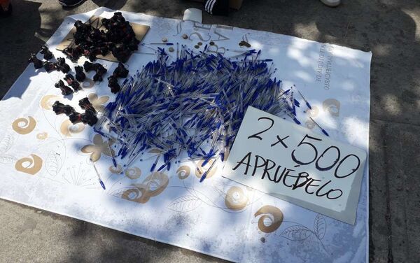 Vendedores ambulantes a las afueras del Estadio Bicentenario vendiendo lápices azules.... y sugiriendo el voto con humor - Sputnik Mundo