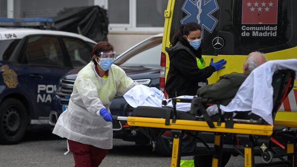 Sanitarias bajando a un paciente de un ambulancia en Madrid - Sputnik Mundo