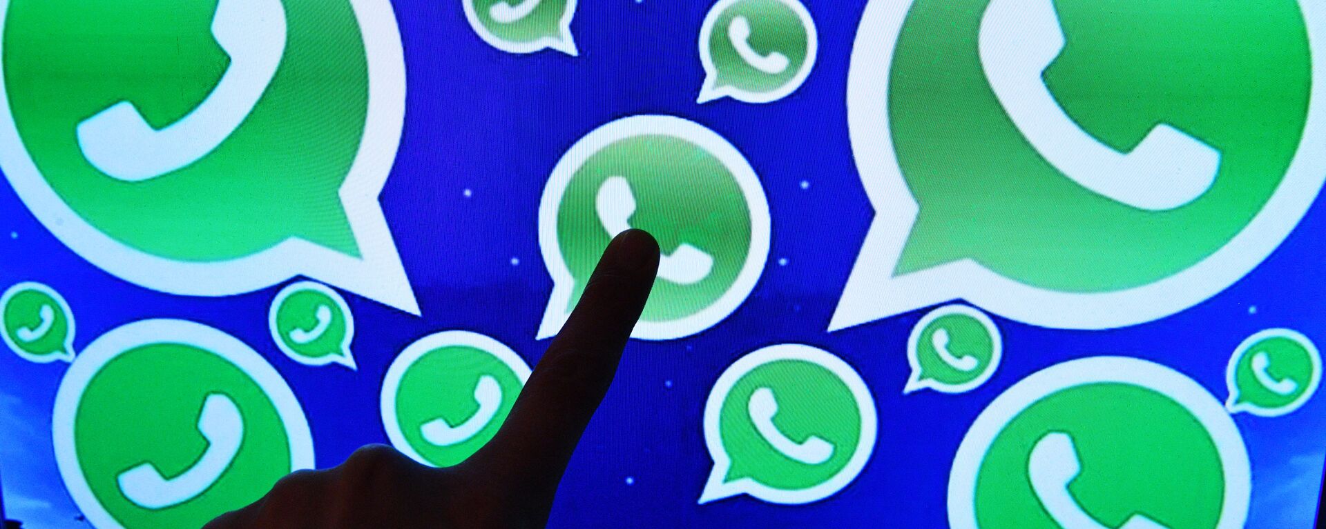 Una persona toca una pantalla en la que se ven diversos logotipos de la aplicación WhatsApp - Sputnik Mundo, 1920, 08.10.2021