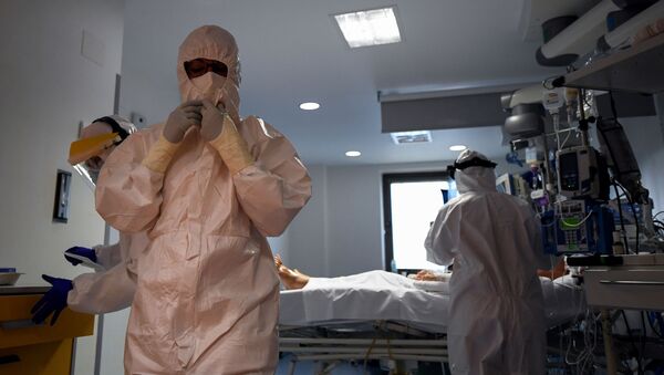 Sanitarios atienden a un paciente con COVID-19 en la Unidad de Cuidados Intensivos del Hospital Ramón y Cajal de Madrid - Sputnik Mundo