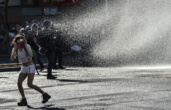 Чилийская полиция поливает демонстрантов из водомета - Sputnik Mundo