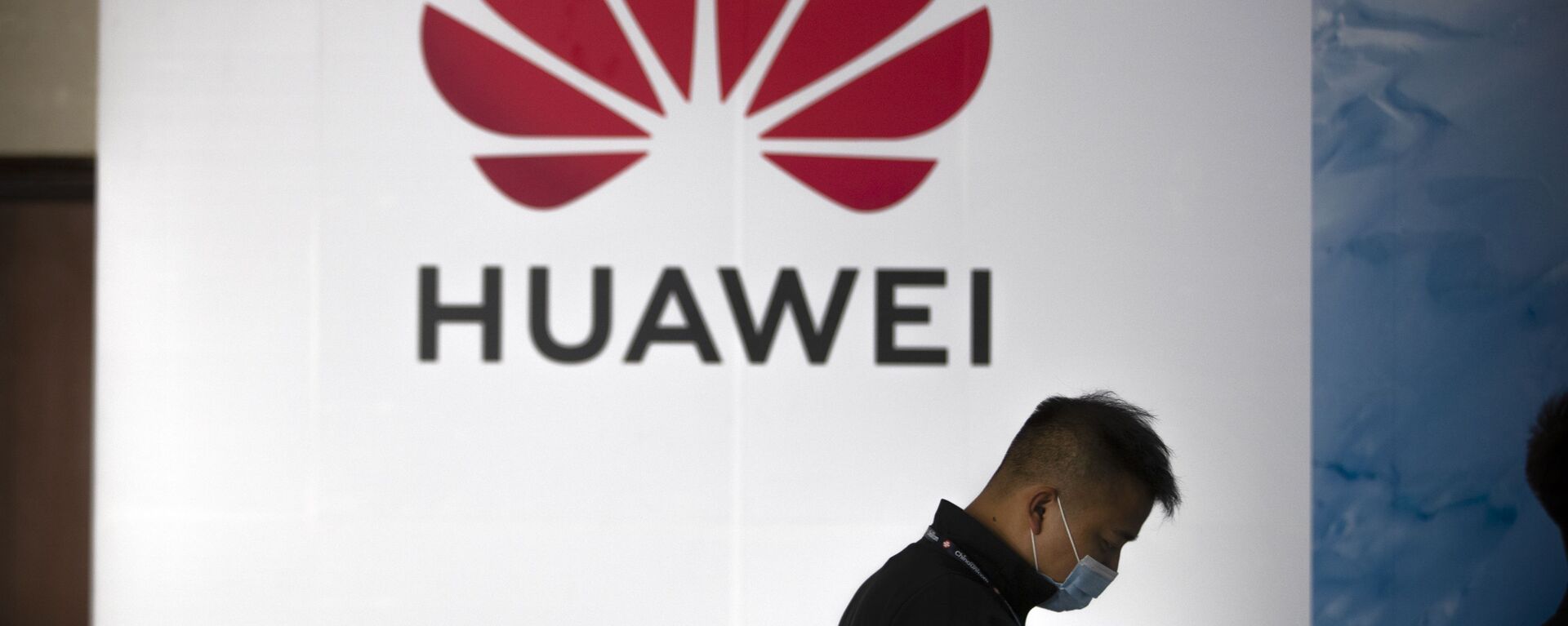 Una persona camina delante del logotipo de Huawei en una feria tecnológica en Pekín - Sputnik Mundo, 1920, 02.02.2022