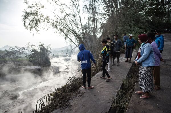 Los residentes de Lumajang, en la isla de Java, observan un arroyo humeante causado por el flujo de lava del volcán Semeru. - Sputnik Mundo