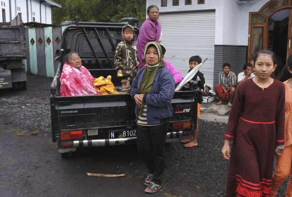 Mujeres y niños se preparan para evacuar sus hogares tras la erupción del monte Semeru en Lumajang, en la isla de Java. - Sputnik Mundo