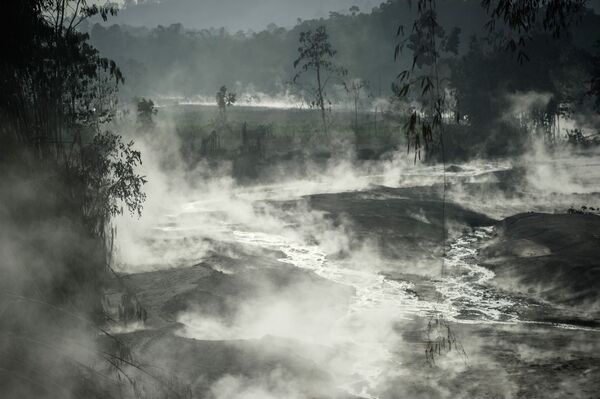 Un arroyo humeante causado por el flujo de lava del volcán Semeru. - Sputnik Mundo