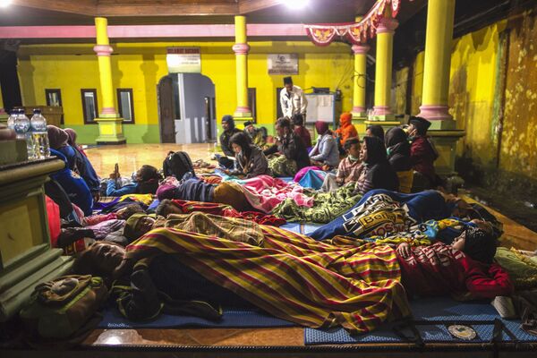 Unas personas descansan en un salón comunitario después de ser evacuadas de la localidad Supiturang a raíz de la erupción del volcán Semeru. - Sputnik Mundo