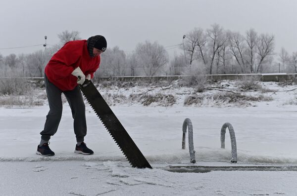En Omsk las temperaturas han bajado hasta los 15 grados centígrados bajo cero, y el río Irtish se ha cubierto con una gruesa capa de hielo. En la foto: un hombre prepara un agujero en el hielo del Irtish en vísperas de la fiesta. - Sputnik Mundo