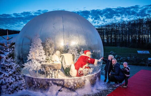 Cada año, el 24 de diciembre, Papá Noel da la vuelta alrededor del mundo para desear una Feliz Navidad a todos los niños.En la foto: un hombre vestido de Papá Noel entretiene a los niños en Aalborg, Dinamarca. - Sputnik Mundo