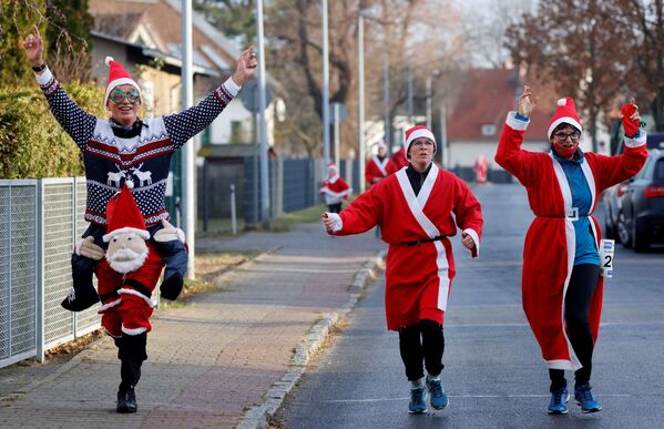 Personas con trajes de Papá Noel durante la carrera del día de San Nicolás en Berlín, Alemania.  - Sputnik Mundo