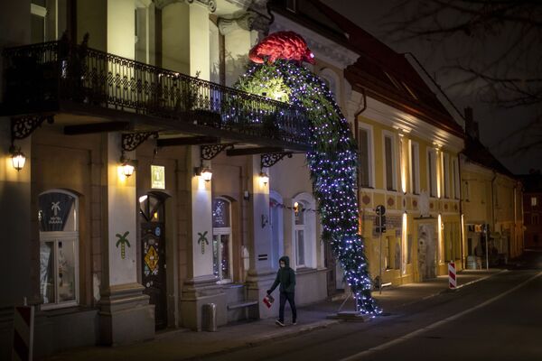 En la capital lituana, Vilnius, debido a la prohibición de las celebraciones masivas, los residentes decidieron decorar los balcones de las casas. En la foto: un balcón decorado con un árbol de Navidad y un pangolín en el centro de Vilnius.  - Sputnik Mundo
