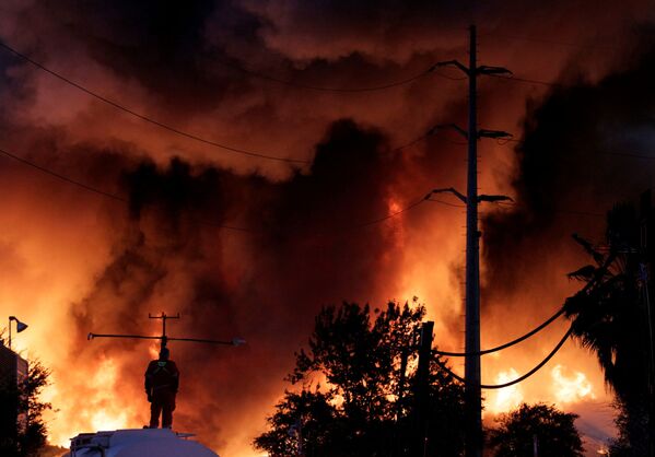 Un bombero intenta apagar un incendio en una planta donde almacenaba chatarra la empresa De Acero en Guadalupe (México). - Sputnik Mundo