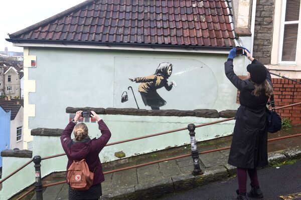 Personas toman fotografías del nuevo trabajo de Banksy en Totterdown, Bristol (Reino Unido). - Sputnik Mundo