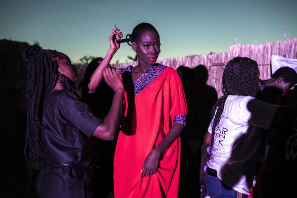 Una modelo se prepara antes de salir a la pasarela durante la Semana de la Moda de Dakar en Senegal. - Sputnik Mundo