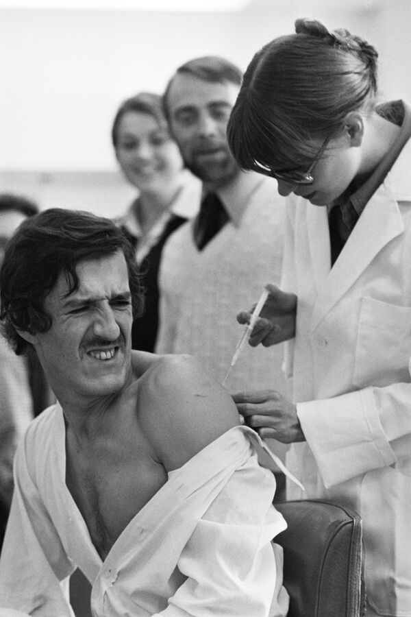 El periodista francés Dominique Faget durante la vacunación contra la gripe en la redacción AFP en París, en 1976. - Sputnik Mundo