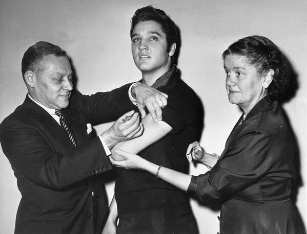 El cantante estadounidense Elvis Presley durante la vacunación contra la poliomielitis en Nueva York, 1956. - Sputnik Mundo