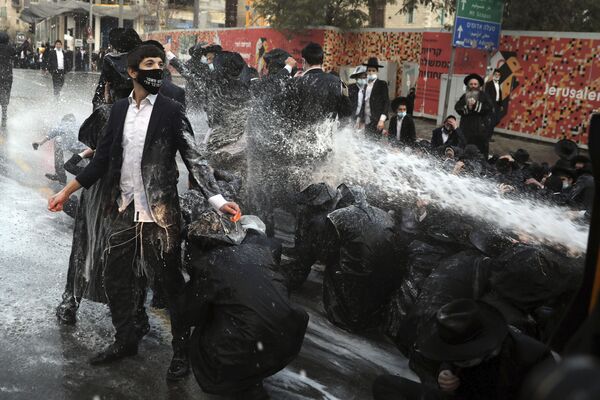 La policía israelí usa cañones de agua para dispersar a los judíos ortodoxos que bloquearon el centro de Jerusalén. La detención de un joven miembro de la comunidad que evadió el servicio militar causó estos disturbios.  - Sputnik Mundo