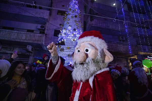 Un hombre vestido de Papá Noel celebra la Navidad en la ciudad de Al-Qamishli, en el noreste de Siria. - Sputnik Mundo
