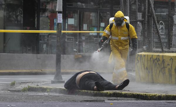 Muertos en las calles y cadáveres en descomposición. Estas fueron las imágenes que impactaron al mundo al principio de la pandemia en Ecuador. Los familiares abandonaban a los fallecidos en la calle y algunos servicios sanitarios se negaban a recoger los cadáveres.En la foto: un trabajador del departamento forense de Quito (Ecuador) desinfecta un cadáver, el 14 de mayo del 2020 - Sputnik Mundo