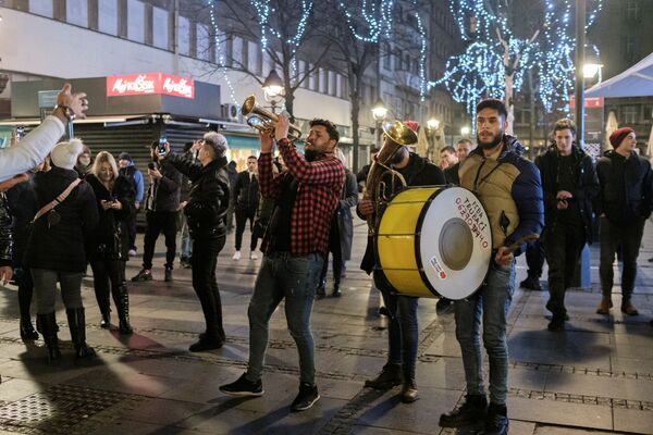 Unas personas cantan y bailan las primeras horas del año nuevo en las calles de Belgrado (Serbia). - Sputnik Mundo