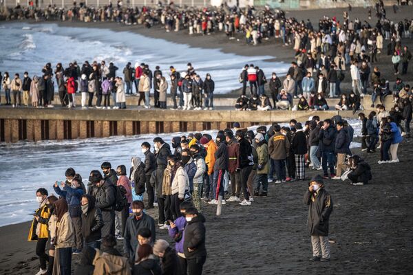 Unas personas se reúnen en una playa de Tokio (Japón) para ver el amanecer del primer día de 2021. - Sputnik Mundo