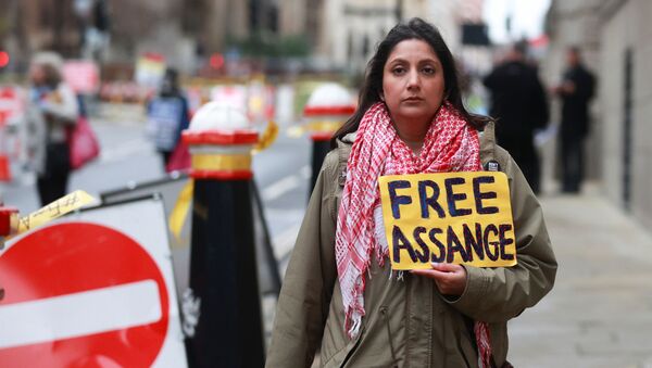 Сторонница основателя WikiLeaks Джулиана Ассанжа держит плакат в его поддержку у Центрального суда в Лондоне - Sputnik Mundo