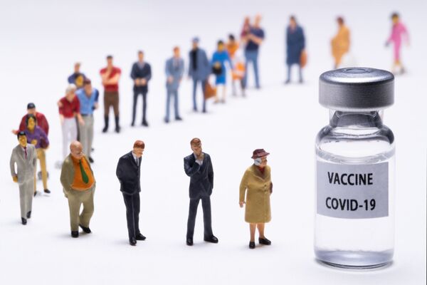 Esta fotografía tomada el 4 de enero de 2021 en París muestra figuritas junto a un vial de vacuna donde se puede leer Vacuna contra el COVID-19. - Sputnik Mundo