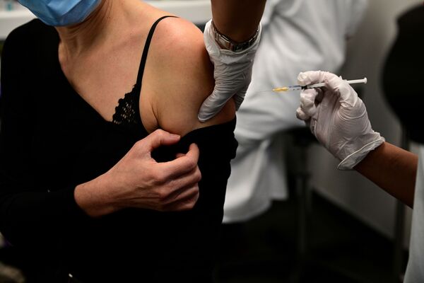 Una mujer recibe una vacuna contra el COVID-19 durante una campaña de vacunación para los trabajadores de la salud mayores de 50 años y/o con comorbilidades, en el centro de vacunación del Hotel Dieu en París, Francia. - Sputnik Mundo