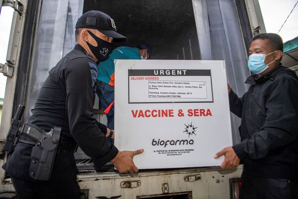 Los empleados descargan una caja de la vacuna de Sinovac contra el COVID-19 que acaba de llegar a la cámara frigorífica del departamento de salud local de Indonesia en Palembang, provincia de Sumatra Meridional. - Sputnik Mundo