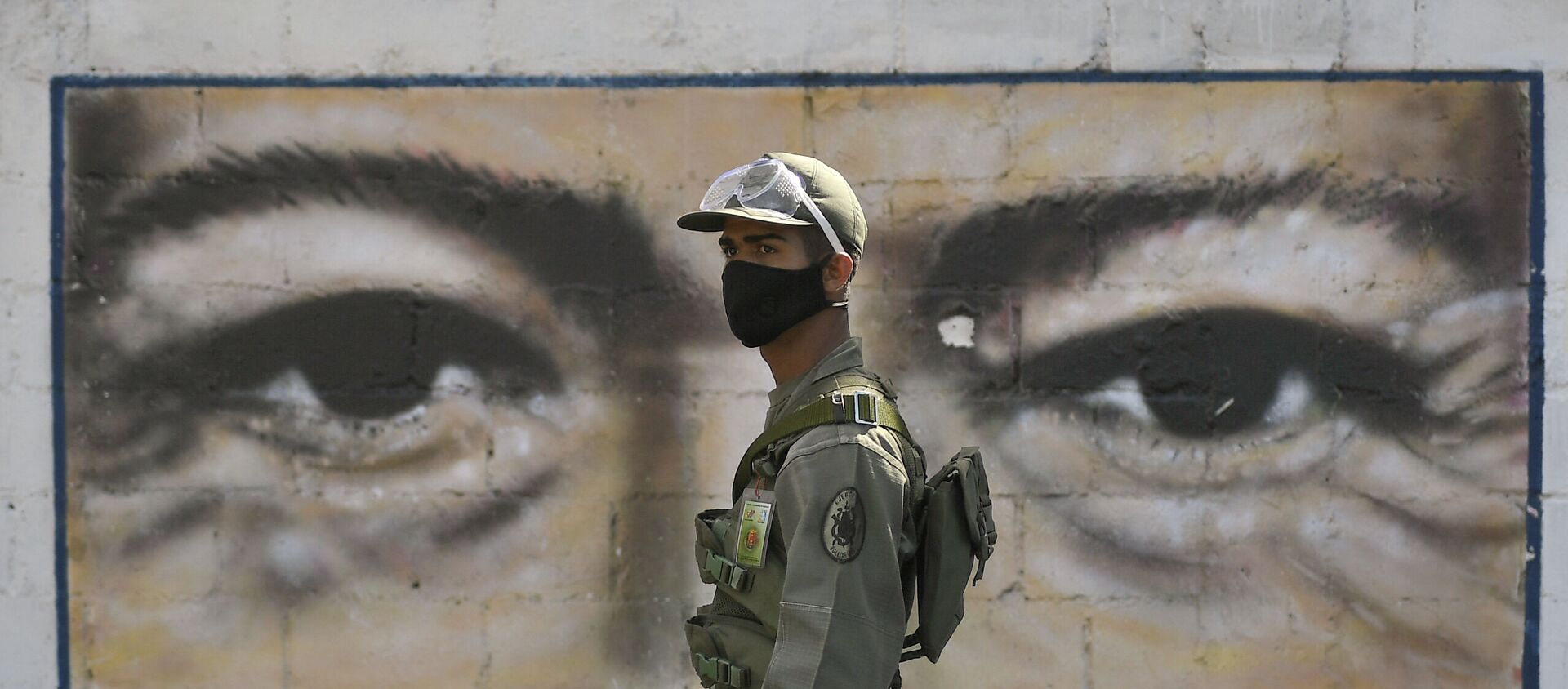Un soldado frente al mural con los ojos de Hugo Chávez en Caracas, Venezuela - Sputnik Mundo, 1920, 05.01.2021