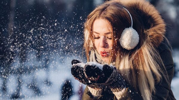 Una joven juega con la nieve en invierno (referencial) - Sputnik Mundo