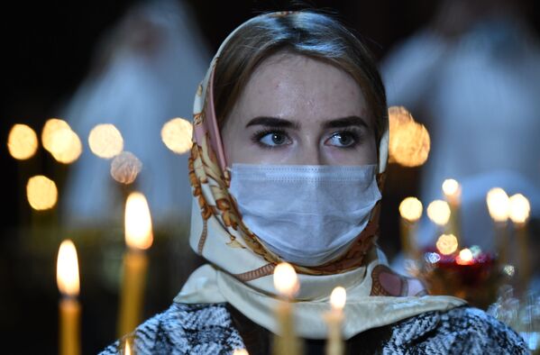 Una fiel durante la misa ortodoxa de Nochebuena en la Catedral del Cristo Salvador de Moscú, el 6 de enero del 2021 - Sputnik Mundo