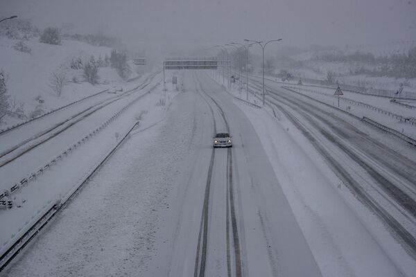 Un automóvil se desplaza por una carretera cubierta de nieve en Rivas Vaciamadrid. - Sputnik Mundo